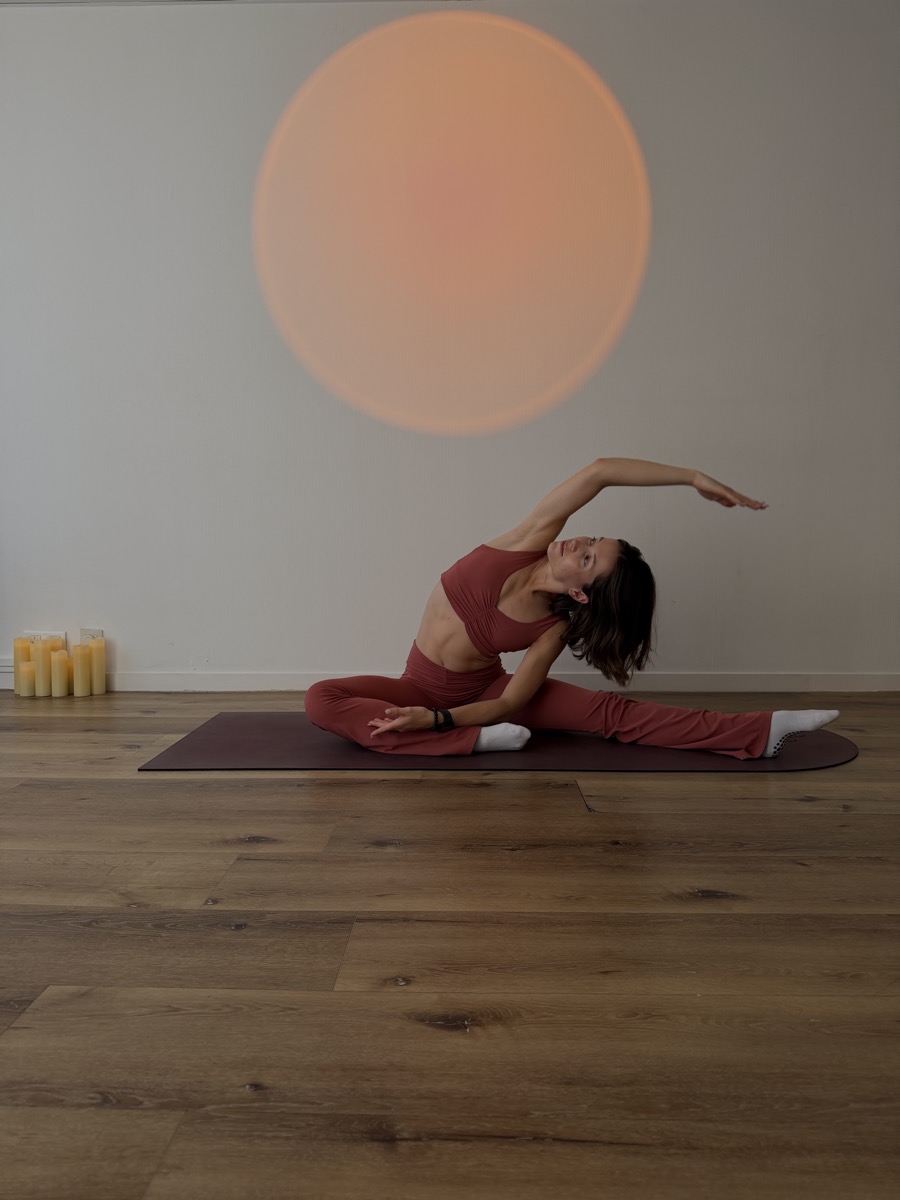Jade Ribal en étirement au sol sur tapis, studio à Biarritz